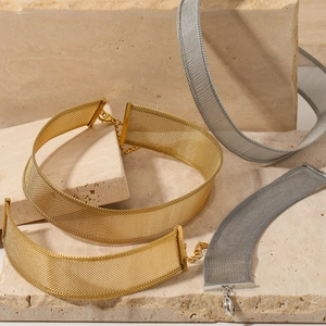 Mesh chain necklace set in gold and silver finish displayed on stone pedestals