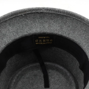 Inside view of a grey wool felt bucket hat featuring a black sweatband and 100% wool label
