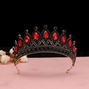 Dettaglio corona barocca dorata con gemme rosse a goccia e cristalli neri lucidi