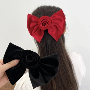 Barrettes à cheveux roses en velours rouge et noir portées par un mannequin élégant