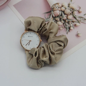 Detail of khaki silk ribbon watch band with sparkling rhinestones and rose gold case