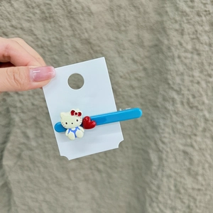 Detailansicht einer blauen Acryl-Haarklammer mit süßer Comic-Katze und rotem Herz