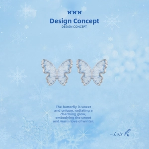 Close-up of blue butterfly earrings with detailed fabric embroidery and silver edges