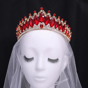 Close-up of golden Baroque bridal crown with large red crystals and white zircons