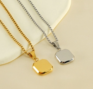 Detail of square geometric pendants in gold and silver finish with box chain texture