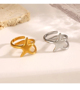 Detail view of gold and silver starfish open rings on minimalist stone background