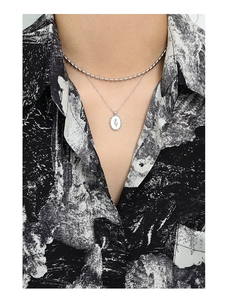 Close-up of double-layer S925 silver necklace with engraved tulip oval pendant