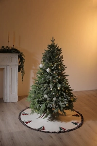 Close-up of a festive 48-needle knitted Christmas tree skirt with tassel edge and cedar patterns