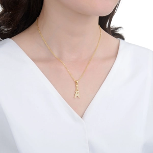 Elegant gold Eiffel Tower necklace with sparkling CZ stones on a female model