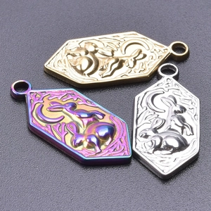 Macro detail of hexagonal rabbit and moon pendants in gold, silver, and rainbow finishes