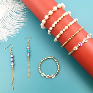 DIY jewelry set featuring pearl beads, heart charms, and star accents on vibrant backdrop