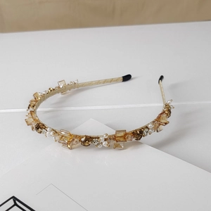 Detail of luxury crystal headband with amber rhinestones and gold thread wrapping