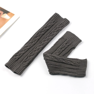 Close-up of cable knit texture on dark gray leg warmers with thick wool yarn