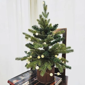 Mini Christmas tree with warm LED globe lights in a brown ribbed pot for home decor