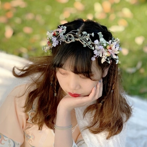 Close-up of a floral crown with purple and pink roses on a woman outdoors