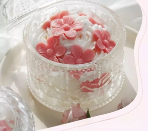 Detailed view of pink cherry blossom scented candle in an embossed glass jar gift