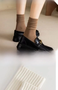 Detail of ribbed cotton mid-calf socks in coffee and white with vintage knit texture