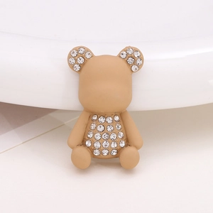 Close-up of a beige cartoon bear charm with sparkling rhinestones for shoes or DIY crafts