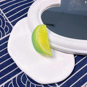 Detail shot of a realistic green lime slice hair clip with textured fruit pulp design