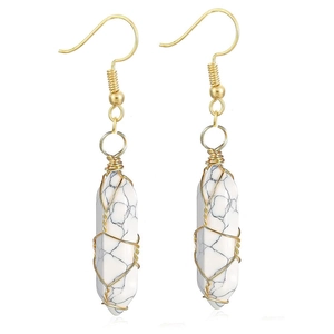 Detailed view of handmade white stone hexagonal drop earrings with gold wire wrapping
