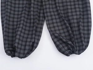 Detailed close-up of elastic cuffs and grey plaid pattern on stylish casual pants