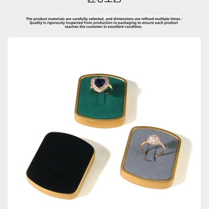 Detail view of sapphire heart rings on velvet metal stands with gold trim