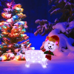 Close-up of lighted Christmas cat figure with red hat and scarf in a snowy yard
