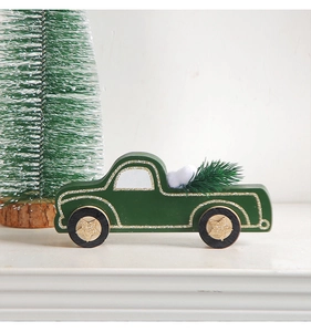 Detail of dark green wooden Christmas truck with golden glitter and pine branches