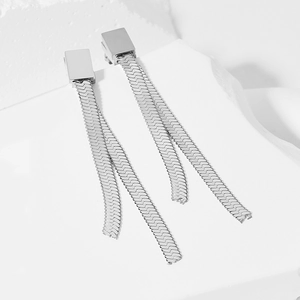 Macro detail of silver square stud earrings with long snake chain tassels on white decor