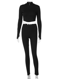 Détail d'un ensemble de sport noir côtelé avec haut court zippé et legging de yoga ajusté