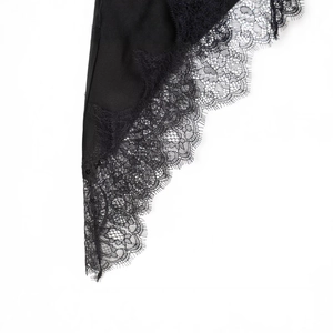 Detailed close-up of premium black lace trim on a stylish asymmetrical casual top for women