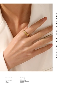 Close-up of golden irregular lava texture adjustable ring worn with white blazer
