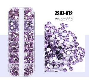 Detailed macro view of purple resin flatback rhinestones for nail art in a 12-grid storage box
