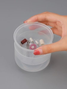 Close-up of hand holding nail drill bit set with ceramic polishers in round storage case