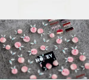 Detail of thin peach nail art stickers with Honey Peach lettering on grey background