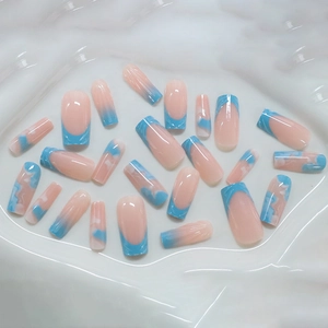 French blue and nude long press-on nails with 3D marble patterns on a white tray