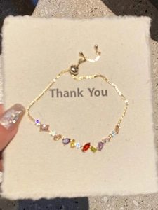 Detail of adjustable 18k gold plated bracelet with multi-colored teardrop and square zircons