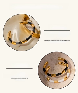 Detail show of gold plated titanium steel open cuff bracelet with black and white enamel