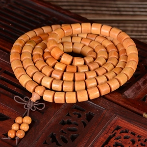 Sandalwood 108 beads Buddhist prayer bracelet spiraled on a carved wooden background