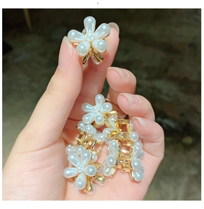 Détails macro de mini pinces à cheveux fleurs en perles avec base en métal doré