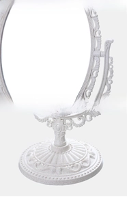 Detail of European vintage desktop makeup mirror with Baroque floral carvings and stable base