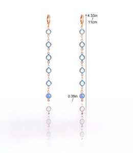 Detail view of rose gold long drop earrings with blue stones and dimensions information