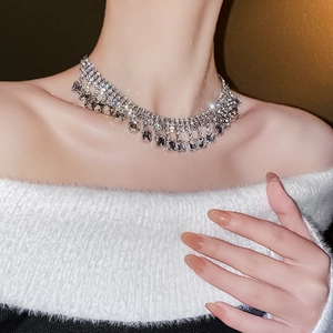 Gros plan d'un collier ras du cou scintillant avec franges de diamants et cristaux carrés
