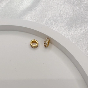 Macro shot of S925 silver spacer beads with double-row cubic zirconia on a white tray
