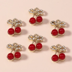 Set of six red cherry pendants with gold rhinestone bows on a soft pink background