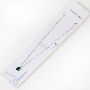 Detail of pear-shaped emerald zircon pendant on 18K gold chain with message card