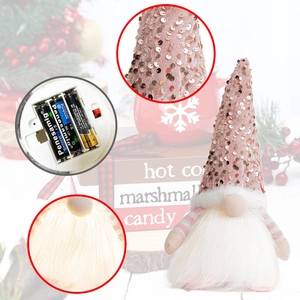 Detail of pink sequin hat and battery compartment on a plush Christmas gnome