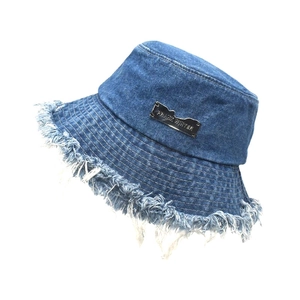 Detail of frayed edge denim bucket hat with silver metallic PRANK WINTER logo plaque