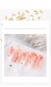Macro detail of champagne gold geometric metal alloy nail art studs on pink nails