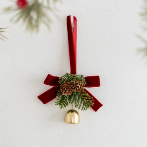 Christmas wreath ornament with red velvet bow, pine cones, and a golden metal bell